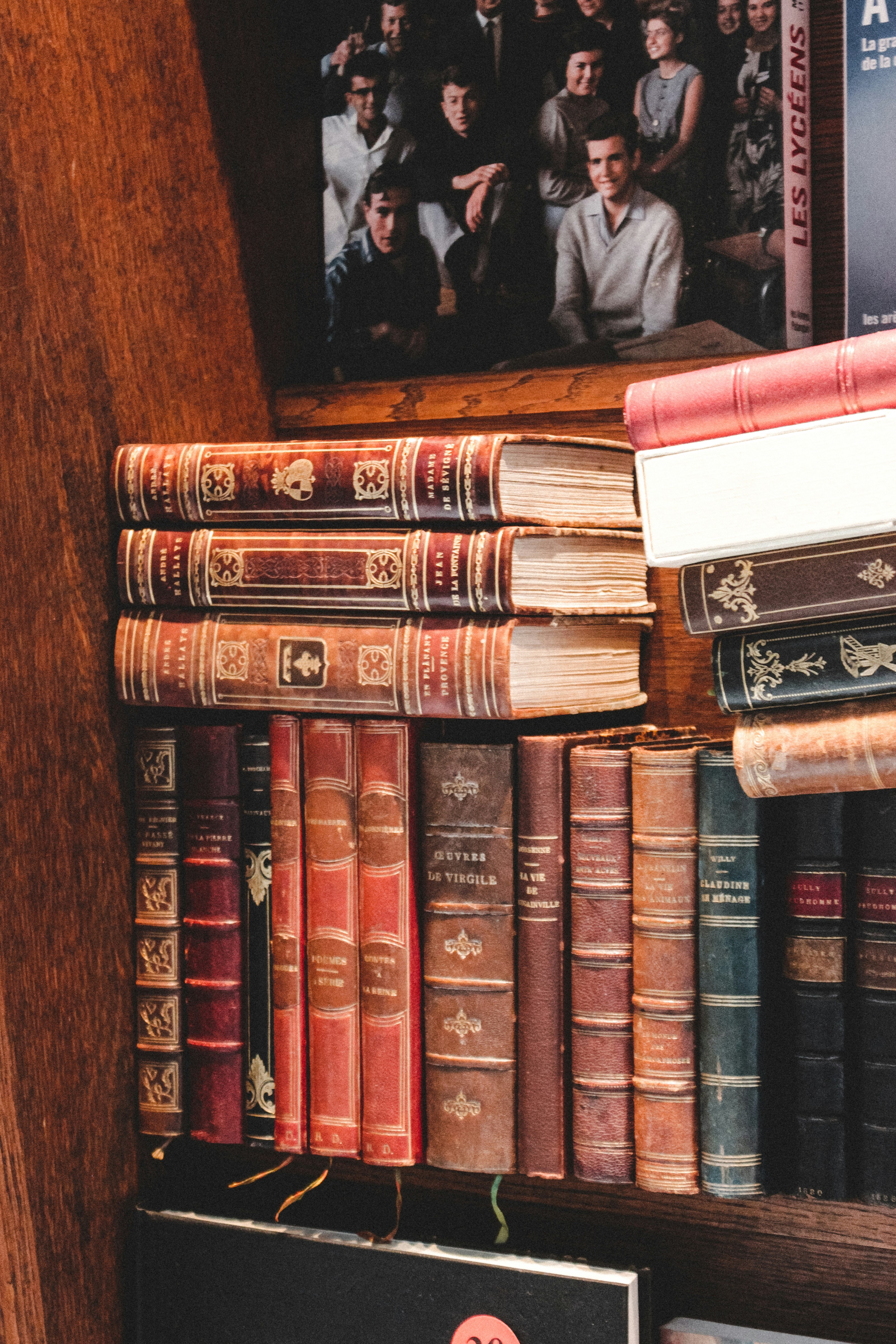 piled books on brown wooden shelf